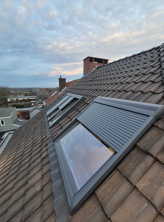 Fenêtres de toit avec volets extérieurs installées dans une toiture en tuiles