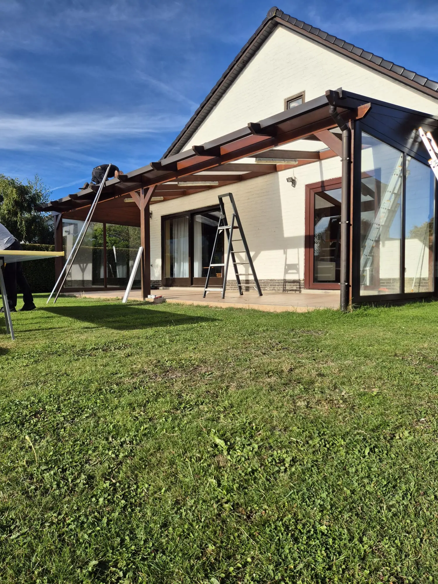 Intervention sur une couverture de terrasse adossée à une maison blanche