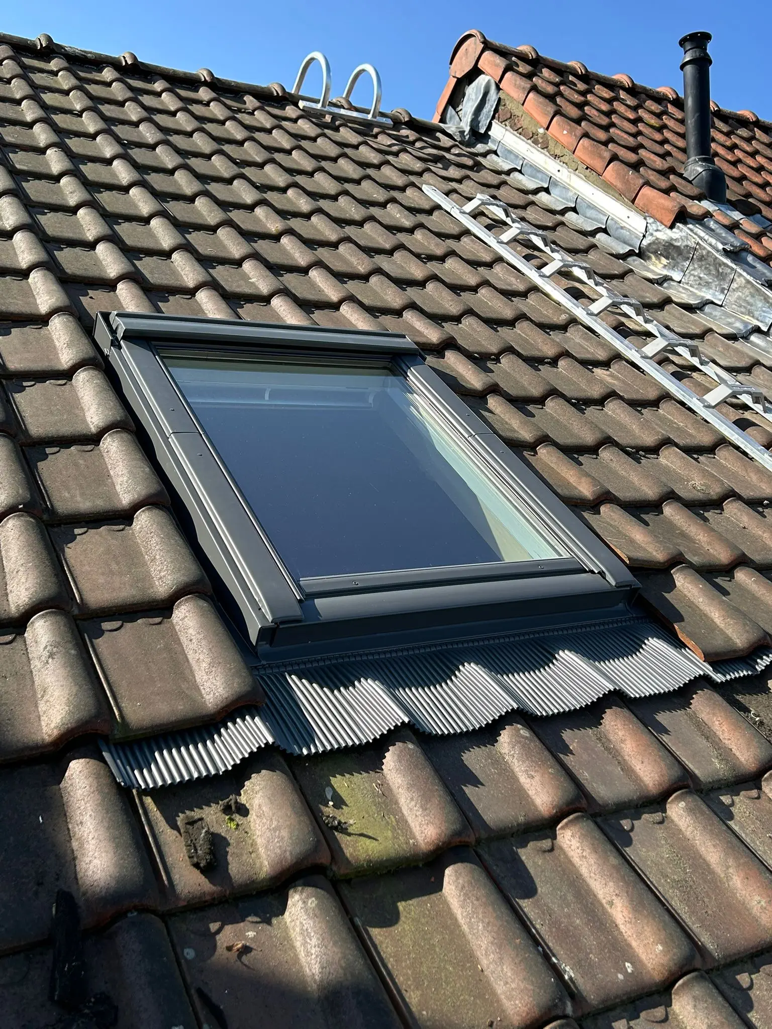 Fenêtre de toit installée dans une couverture en tuiles